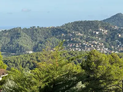 a view of a mountain with trees and houses at CASA CON JARDIN, SAUNA, PISCINA PRIVADA y NATURALEZA CERCA DE BARCELONA in Pallejá