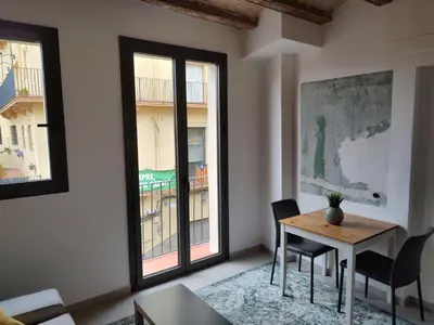 a living room with a table and chairs and windows at ANTIC Manresa 1 in Manresa
