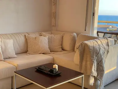 a living room with a white couch and a table at Sitges Apartamente frente al mar con piscina in Sitges