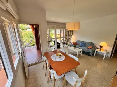 a living room with a wooden table and chairs at Apartamento Montebello in Sant Vicenç de Montalt