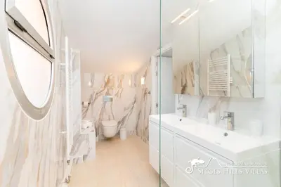a white bedroom with a white bed and a table at Amazing views Villa Alizee with private pool sea views and Air Conditioning in Olivella