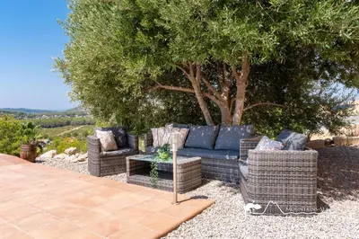 a living room with a table and chairs at Amazing views Villa Alizee with private pool sea views and Air Conditioning in Olivella