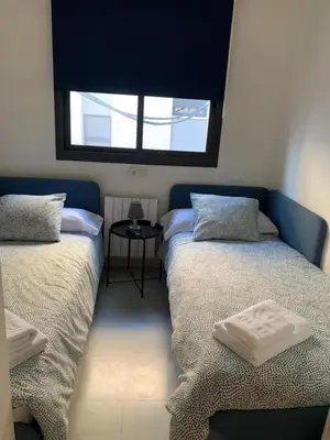 two beds in a room with a window at Casa tonet in Badalona