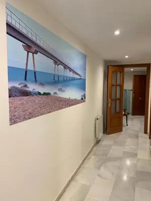 a hallway with a painting of a pier on the wall at Casa tonet in Badalona