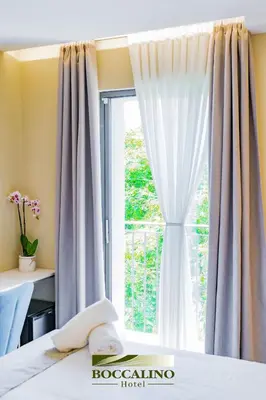 a bedroom with a large bed in a room at Hotel Boccalino Sitges in Sitges