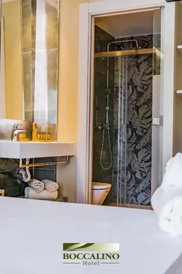 a hotel room with two beds and a window at Hotel Boccalino Sitges in Sitges