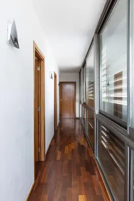 a hallway with wooden floors and a large window at Dialez Holidays - Villarenys in Arenys de Mar