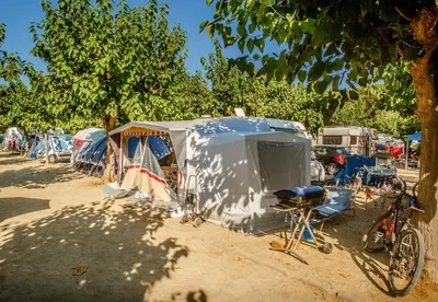 a group of tents and a bike parked in a field at Càmping Bellsol in Pineda de Mar