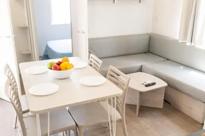 a room with a table with a bowl of fruit on it at Càmping Bellsol in Pineda de Mar