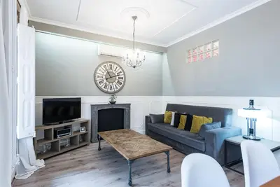 a living room with a couch and a clock on the wall at The Collection Barcelona - Eixample 3BD Apartment with Private Terrace in Barcelona