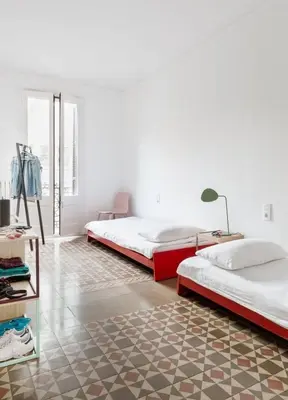 a bedroom with two beds and a table with a lamp at GuestReady - Acogedor piso al lado de Pl. Cataluña in Barcelona