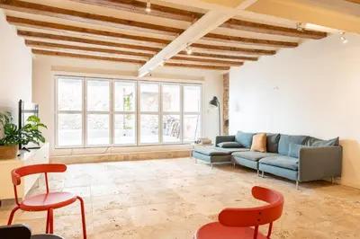 a living room with a blue couch and red chairs at GuestReady - Unique Retreat in Barcelona in Barcelona