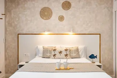 a bedroom with a large white bed with two candles on it at Lodging Apartments Almirall Beach 32 in Barcelona