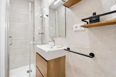 a bathroom with a white sink and a shower at Lodging Apartments Almirall Beach 32 in Barcelona
