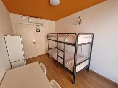 a room with two bunk beds and a table at Arc House Barcelona in Barcelona