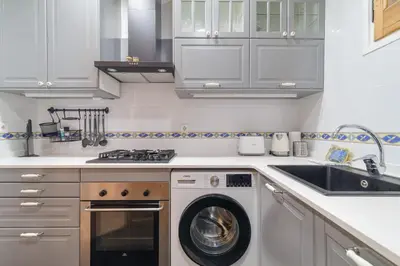 a kitchen with a washing machine and a sink at GuestReady - Bright apartment with balcony in Barcelona