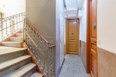 a hallway with stairs and a wooden door at GuestReady - Bright apartment with balcony in Barcelona