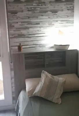 a bed with a table and a pillow in a room at Apartment close to the beach and the town centre in Castelldefels