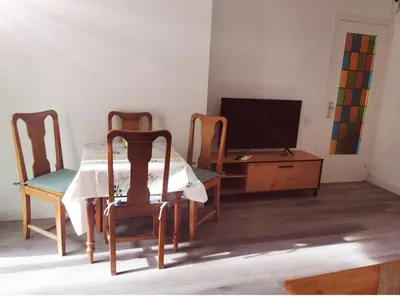 a room with a table and two chairs and a tv at Apartment close to the beach and the town centre in Castelldefels