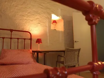a bedroom with a bed and a table with a lamp at Ca l'Agnès in Montseny