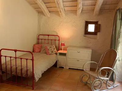 a bedroom with a bed and a table and chairs at Ca l'Agnès in Montseny