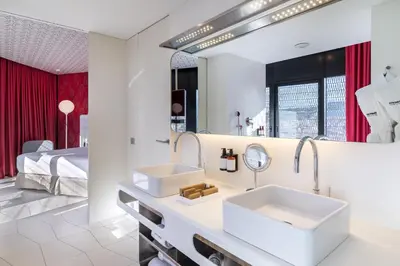 a bathroom with two sinks and a bed at Barceló Raval in Barcelona