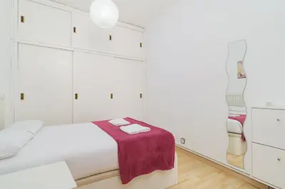 a white bedroom with a bed with a purple blanket at GuestReady - Comfortable Retreat next to the beach in Barcelona
