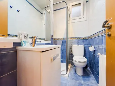 a blue tiled bathroom with a toilet and a sink at GuestReady - Comfortable Retreat next to the beach in Barcelona