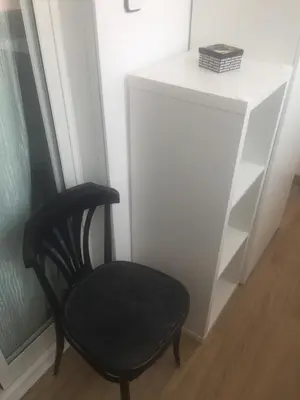 a black chair sitting next to a white shelf at Apartment Aptucat in Barcelona