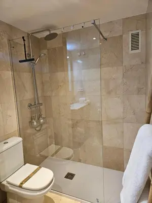 a bathroom with a glass shower with a toilet at EstudioSueñosSuite in Sant Just Desvern