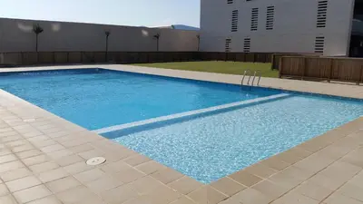 a swimming pool with blue water in a building at Apartment Airport Barcelona Premium in Viladecáns