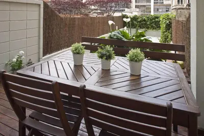 a wooden table with potted plants on a balcony at Flateli Llúria in Barcelona