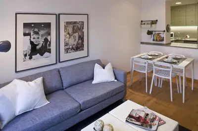 a living room with a blue couch and a table at Flateli Llúria in Barcelona