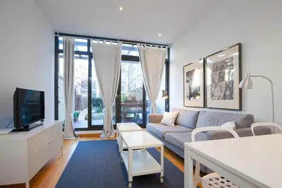 a living room with a couch and a tv at Flateli Llúria in Barcelona