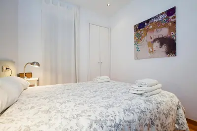 a white bedroom with a bed with towels on it at Flateli Llúria in Barcelona