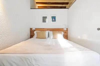 a bedroom with a large bed with white sheets and pillows at Flateli Borrell in Barcelona