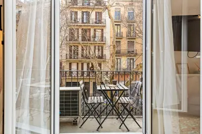 a balcony with a table and chairs outside a window at Flateli Borrell in Barcelona