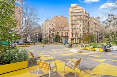 a plaza with chairs and buildings in a city at Flateli Borrell in Barcelona