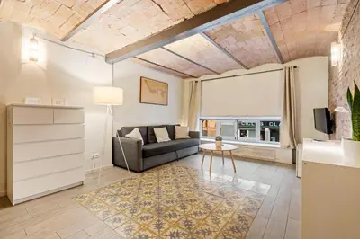 a living room with a couch and a table at Flateli Fabra in Barcelona