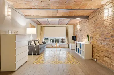 a living room with a brick wall and a couch at Flateli Fabra in Barcelona