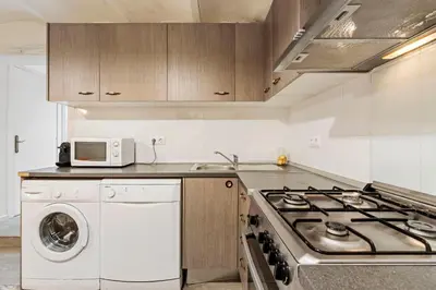 a kitchen with a stove and a washing machine at Flateli Fabra in Barcelona