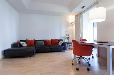 a living room with a couch and a table and a red chair at Flateli Mallorca-Passeig de Gracia in Barcelona