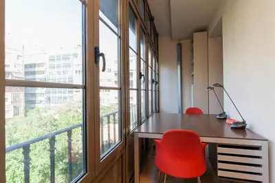 an office with a desk and red chairs and a window at Flateli Mallorca-Passeig de Gracia in Barcelona