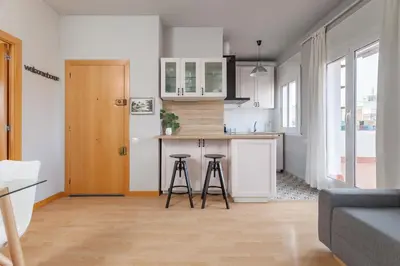 a kitchen with a counter and stools in a room at Flateli Roger 16 in Barcelona