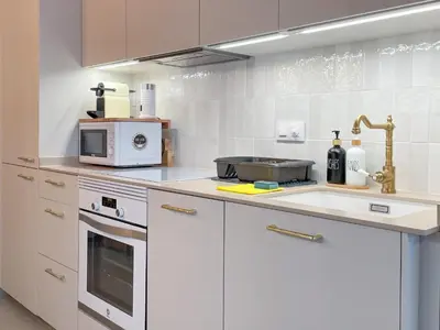a white kitchen with a microwave and a stove at Apartment Rafol in Vilanova i la Geltrú