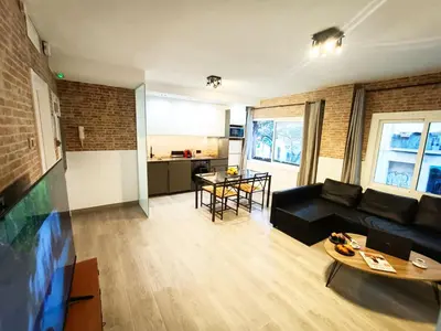 a living room with a black couch and a table at La Fira - Paralelo 1 in Barcelona