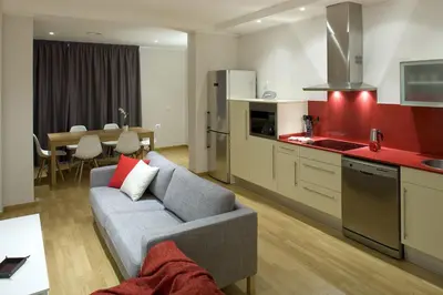 a living room with a couch and a kitchen at Flateli Pelayo H1 in Barcelona