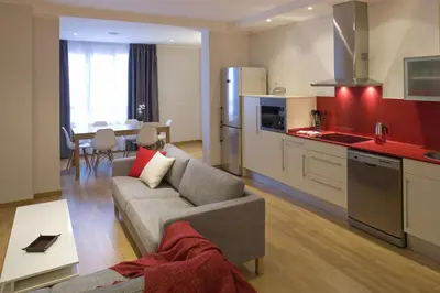 a living room with a couch and a kitchen at Flateli Pelayo H1 in Barcelona