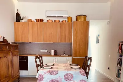 a kitchen with a table with wine glasses on it at Bright airy family style 7 min walk to beach in Caldes d'Estrac
