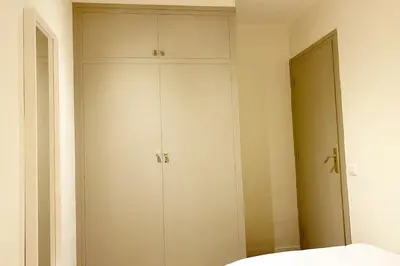 a bedroom with a white cabinet and a mirror at Bright airy family style 7 min walk to beach in Caldes d'Estrac
